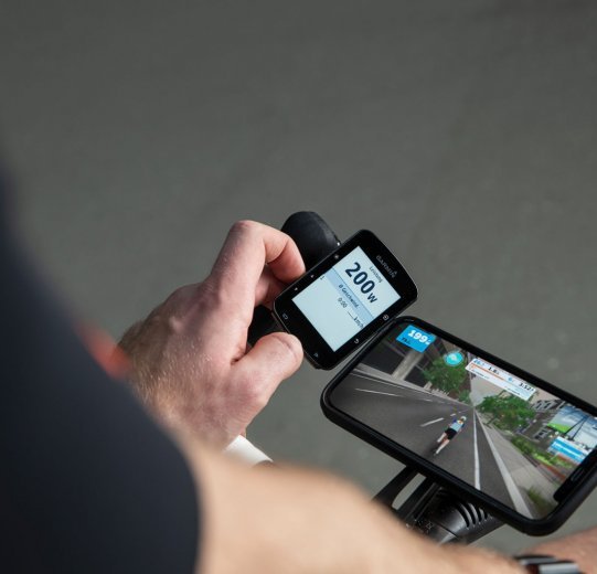 Un compteur de vélo Garmin Edge affiche les données de puissance en watts pendant un entraînement sur Zwift.