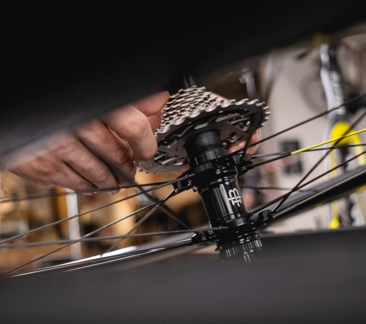 Close-up: A drivetrain cassette is being mounted onto a SRAM freehub body on a Black Inc wheel.