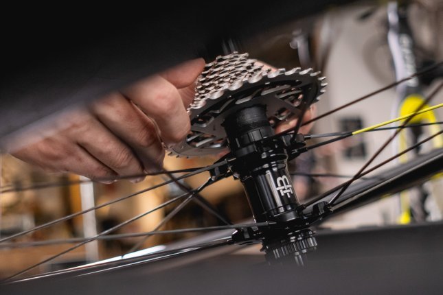 Close-up: A drivetrain cassette is being mounted onto a SRAM freehub body on a Black Inc wheel.