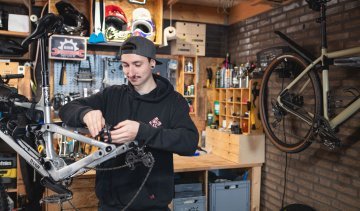 Le mécanicien de bc Pascal vérifie le frein arrière d'un VTT RAAW dans un atelier de bricolage.