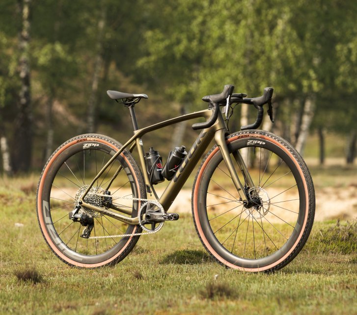 A Look gravel bike with Zipp wheels stands on a meadow.