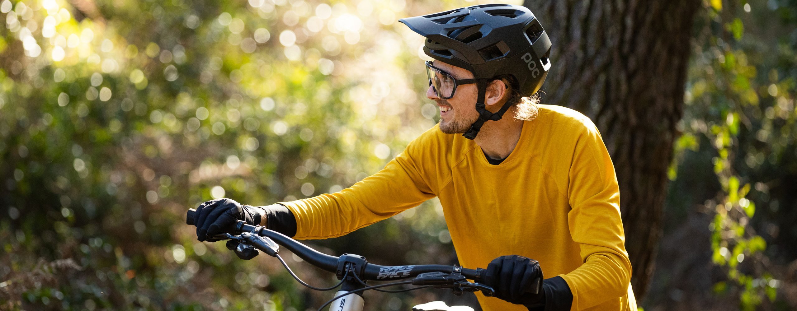 Mountainbiker mit sommerlichen gelben MTB Trikot schiebt sein Bike
