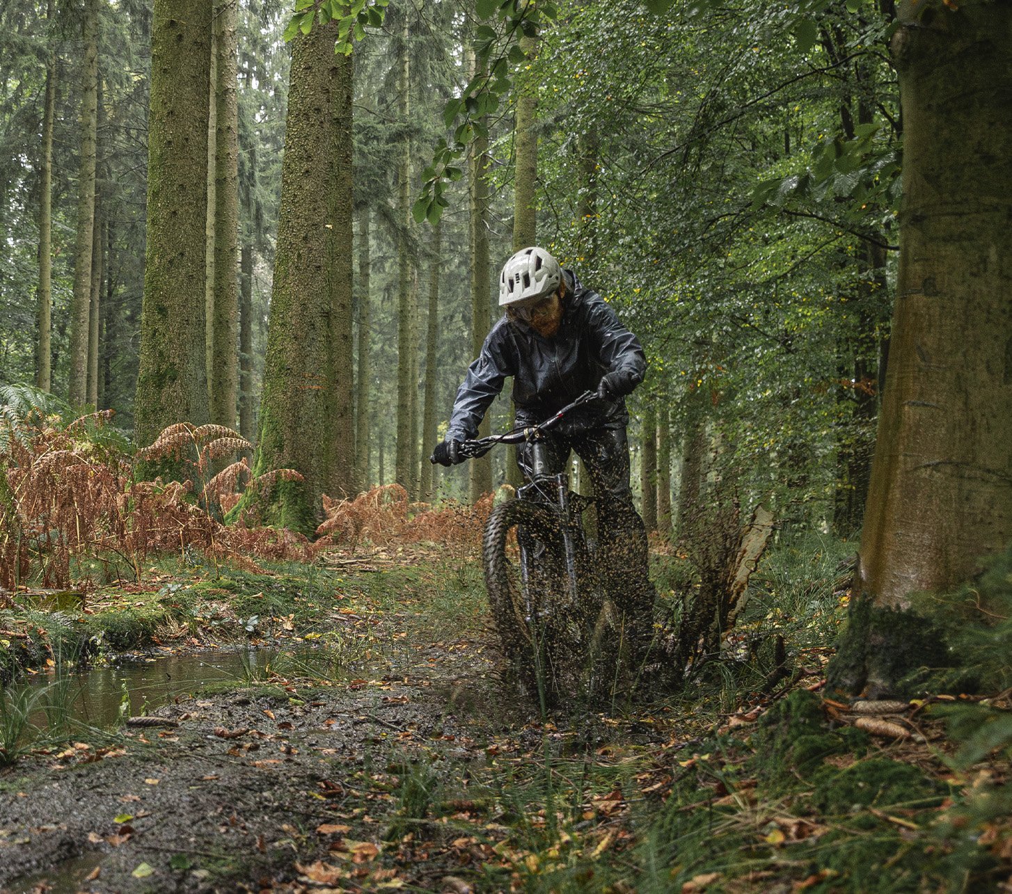 Arno von bike components fährt mit seinem Moutainbike durch schlammige Waldpfützen