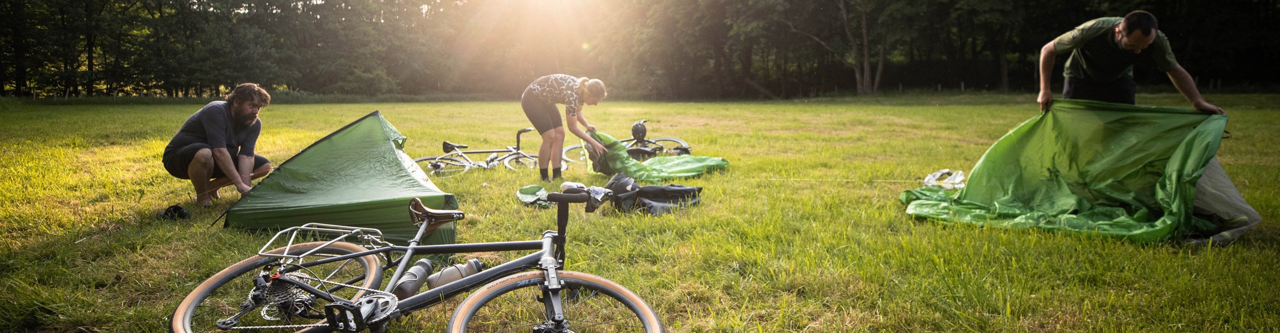 Gravelbiker schlagen ihre Zelte bei ihrem Bikepacking Trip auf.