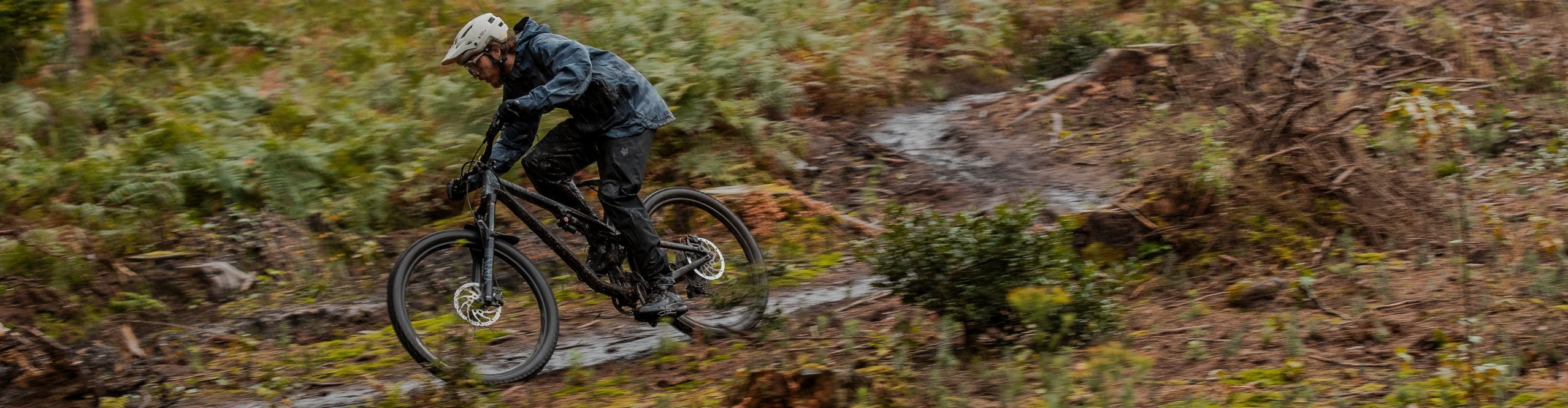 Arno von bike components fährt mit seinem Moutainbike durch schlammige Waldpfützen