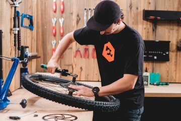 Bicycle mechanic Pascal installs a cassette on a wheel in the bc workshop studio.