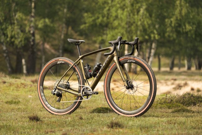 A Look gravel bike with Zipp wheels stands on a meadow.