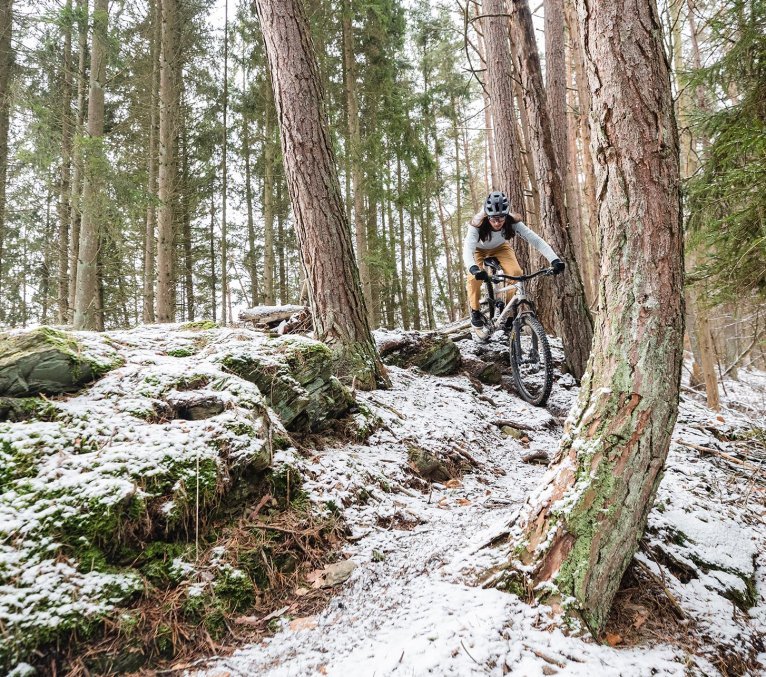 Mountainbiker fährt durch einen schneebedeckten Wald