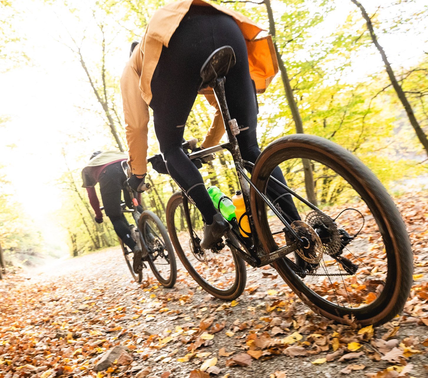 Dynamisches Foto von zwei Gravel Bikern durch eine Herbstwald