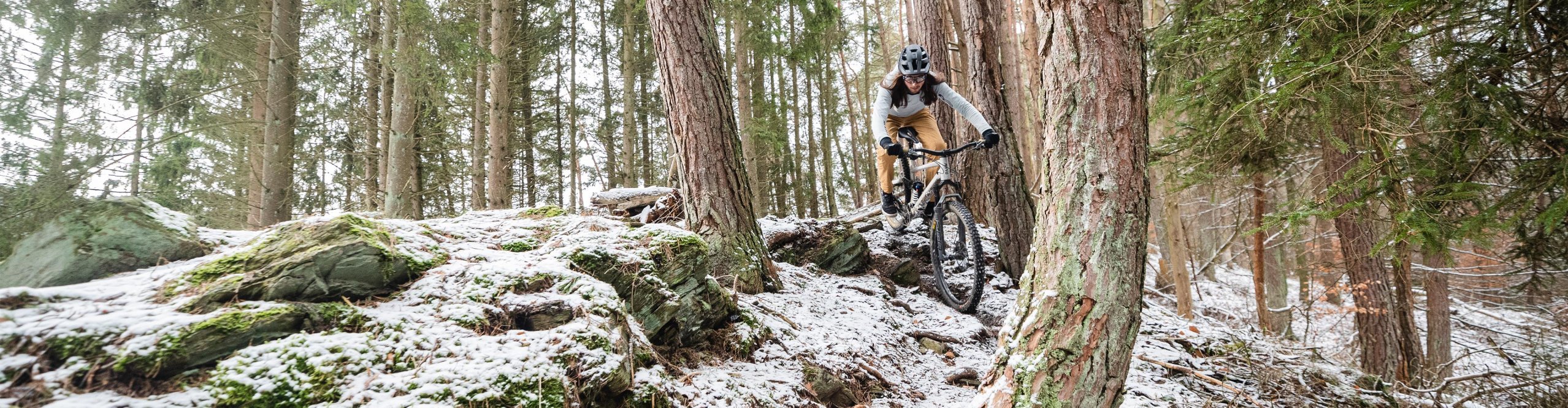 Mountainbiker fährt durch einen schneebedeckten Wald